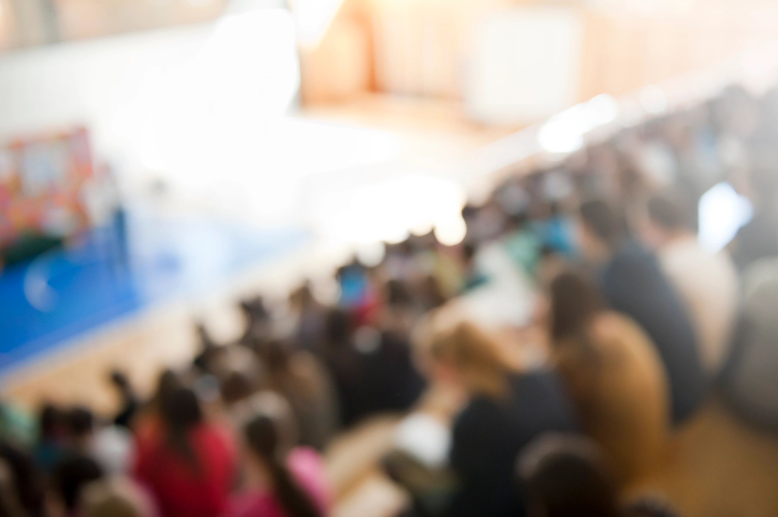 Wide view of attendees focused on a conference stage